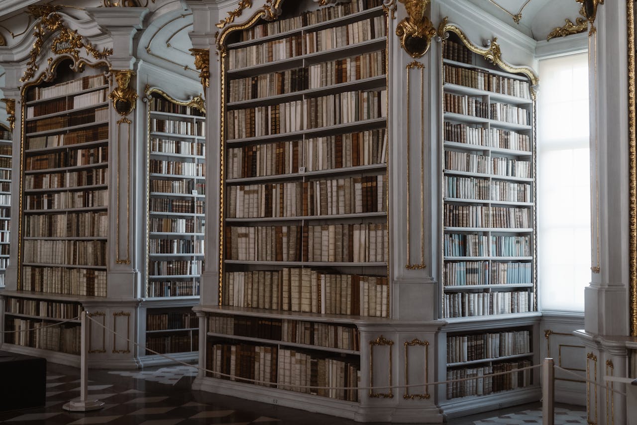 An opulent library featuring classical architecture and ornate woodwork with a vast collection of decorative books.